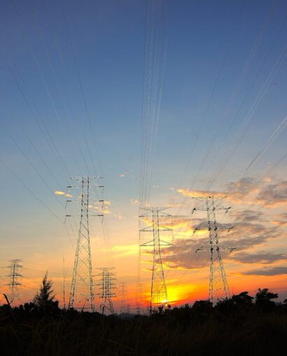 Three Black Metal Electricity Posts during Golden Hour